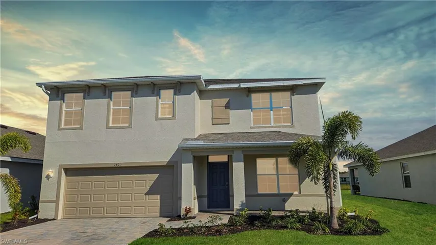 View of front facade featuring a garage and a yard