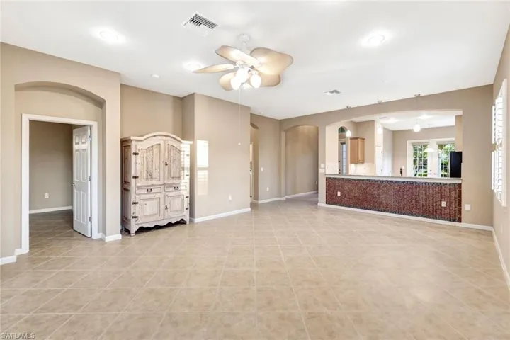 Unfurnished living room with ceiling fan and light tile patterned floors