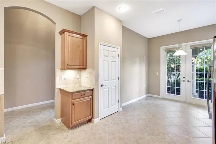 Kitchen with light stone counters, pendant lighting, tasteful backsplash, and light tile patterned flooring