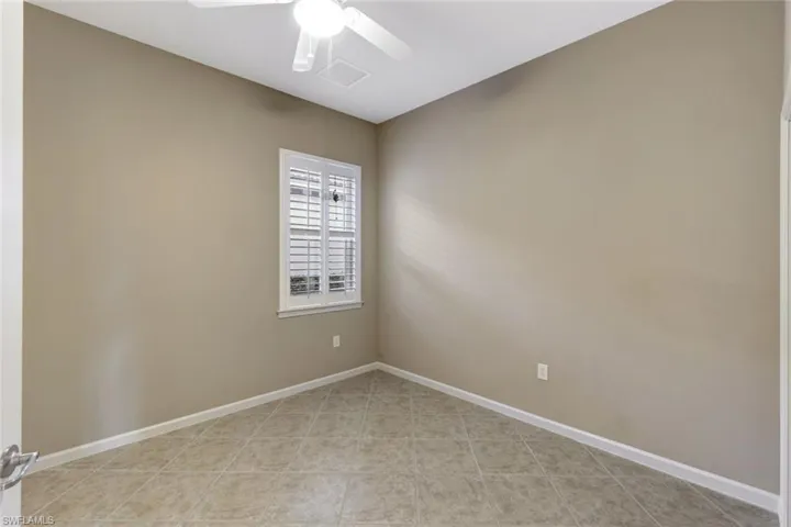 Tiled empty room featuring ceiling fan