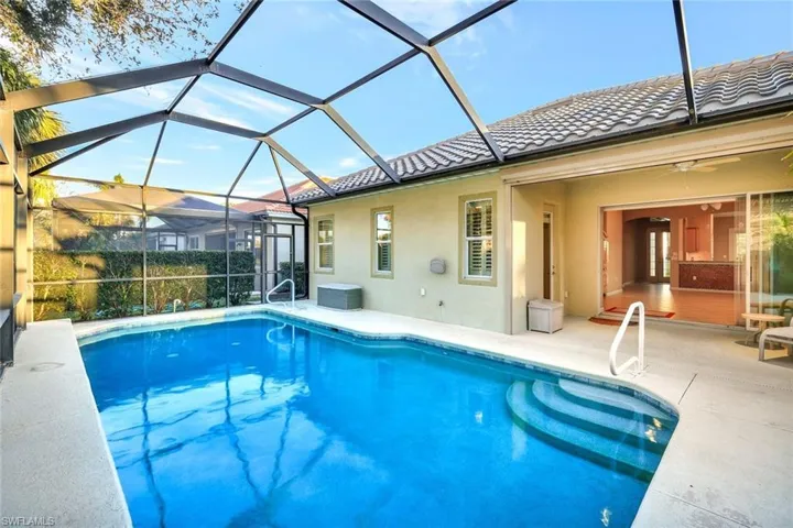 View of swimming pool featuring a lanai, ceiling fan, and a patio area