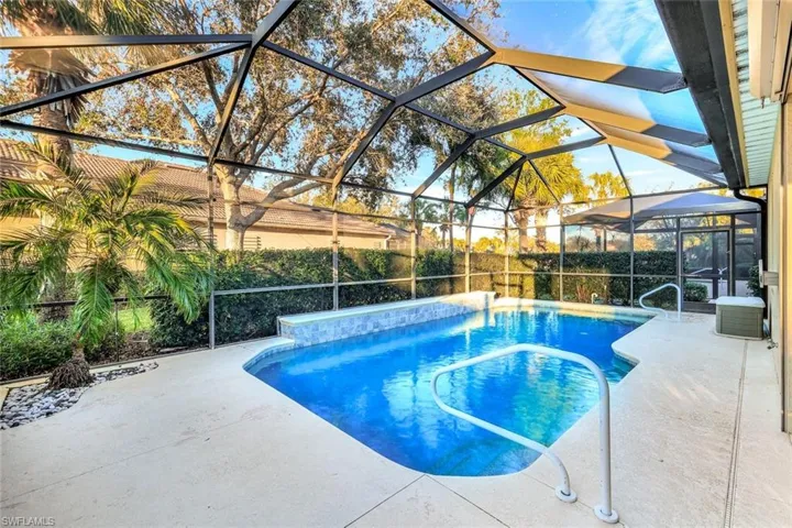 View of pool featuring a patio and glass enclosure