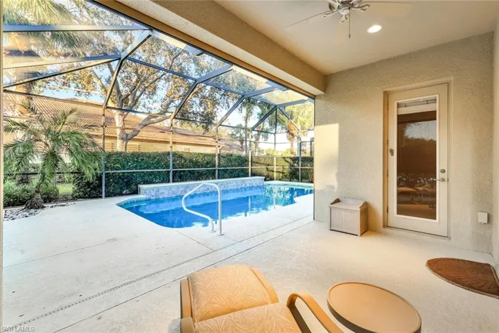 View of swimming pool with a patio, a lanai, and ceiling fan