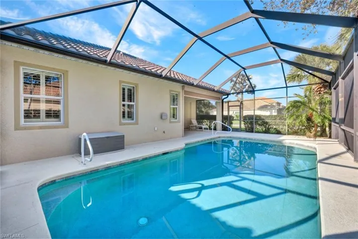 View of swimming pool featuring a patio and glass enclosure