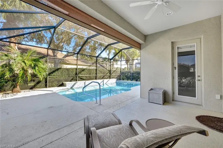 View of pool featuring ceiling fan, glass enclosure, and a patio area