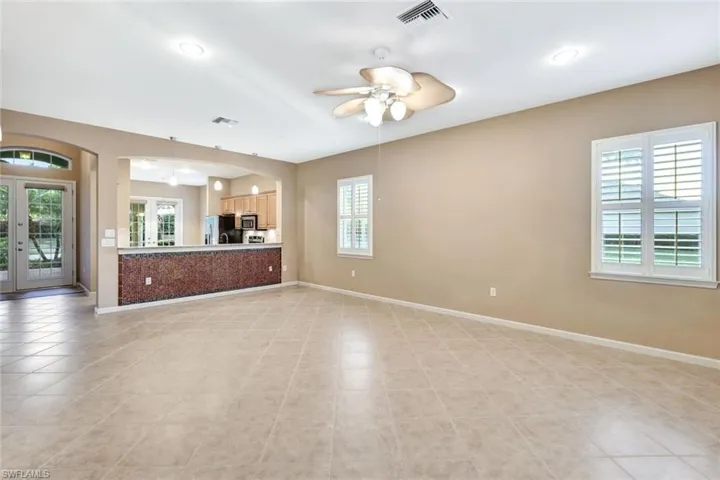Unfurnished living room with ceiling fan and french doors