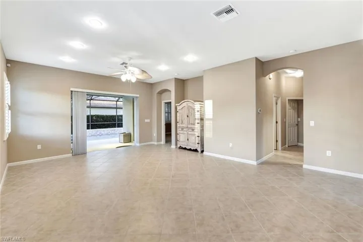 Unfurnished living room with light tile patterned floors and ceiling fan