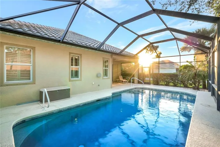 View of pool featuring a patio and glass enclosure