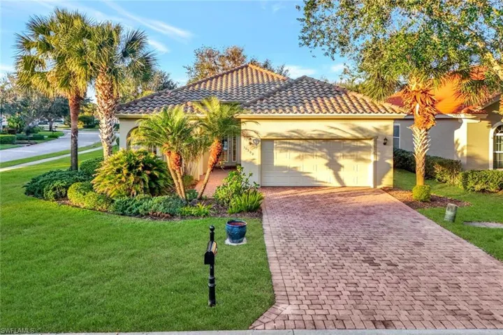 Mediterranean / spanish home featuring a garage and a front yard