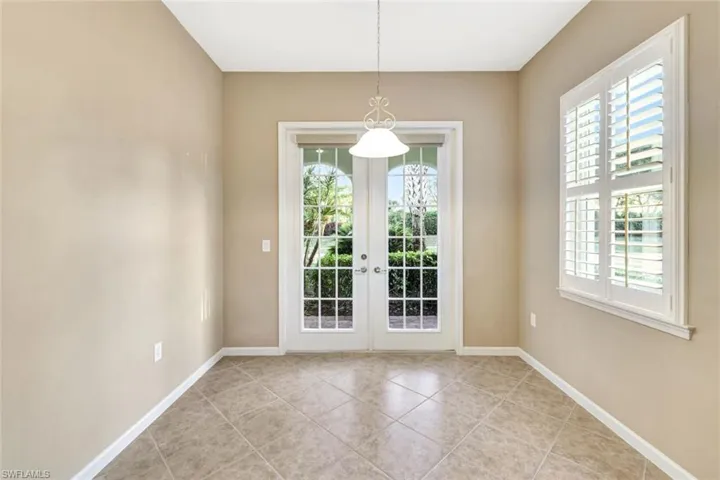 Unfurnished dining area featuring french doors, a healthy amount of sunlight, and light tile patterned flooring