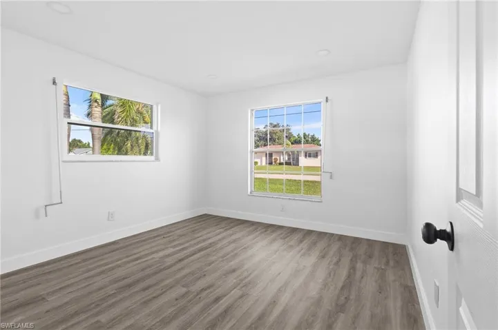 Spare room with wood finished floors and recessed lighting