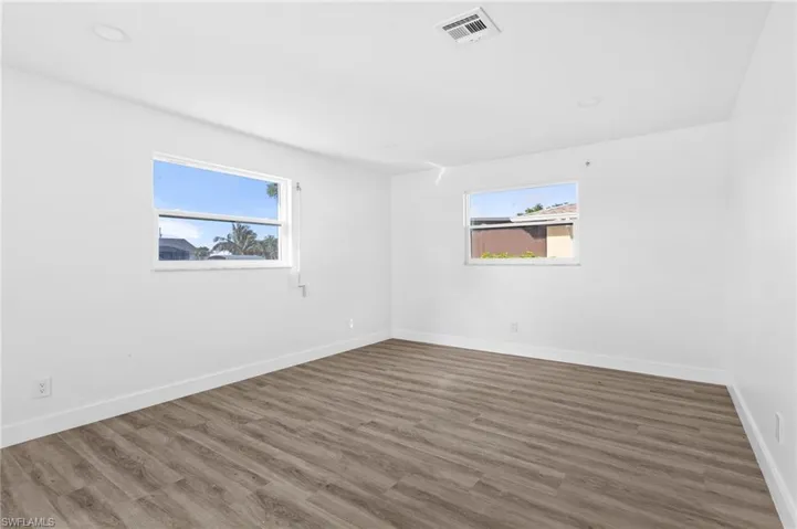 Spare room featuring dark wood finished floors and recessed lighting