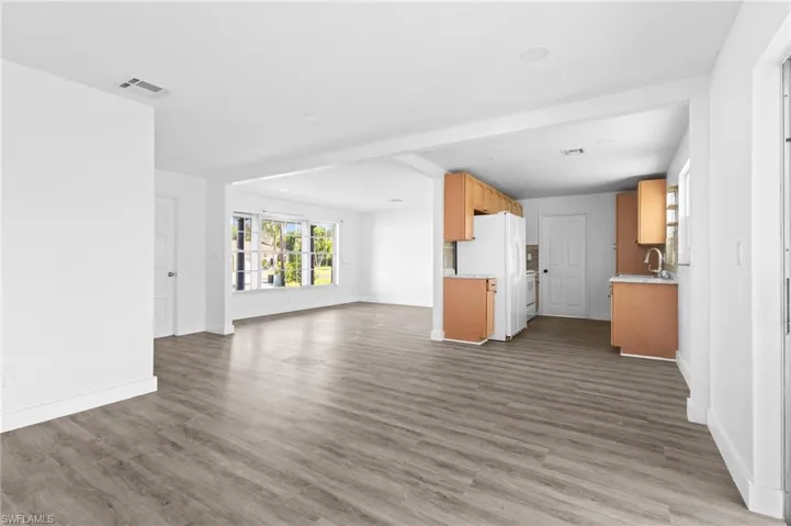 Unfurnished living room with dark wood finished floors and baseboards