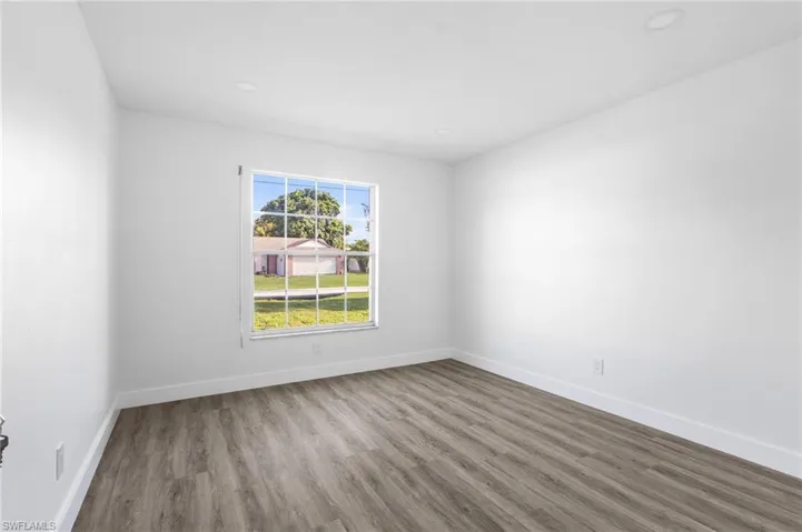Spare room with wood finished floors and recessed lighting