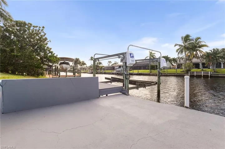 View of patio / terrace featuring boat lift, a dock, and a water view
