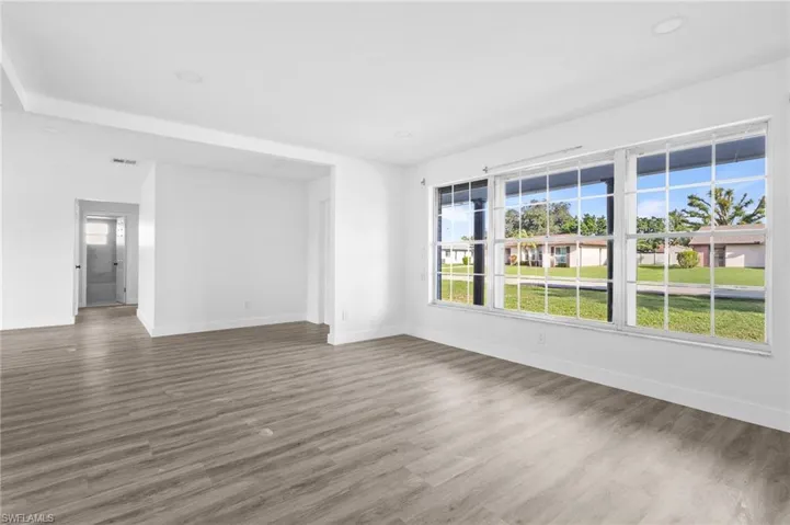 Unfurnished living room featuring wood finished floors and recessed lighting