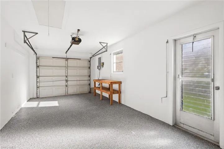 Garage featuring a garage door opener and electric panel