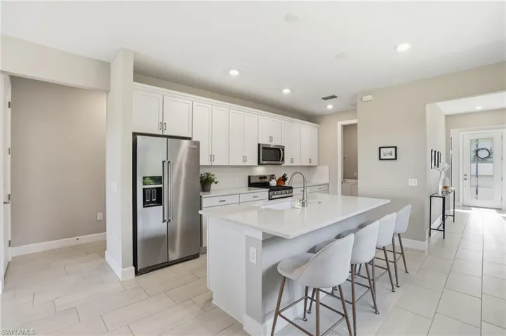 Open concept kitchen with stainless steel appliances and quartz countertops.