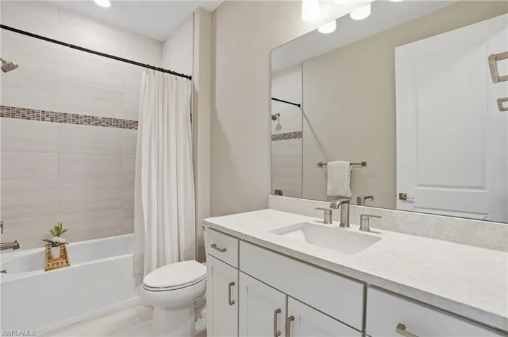 Full guest bathroom with large vanity and quartz countertop.