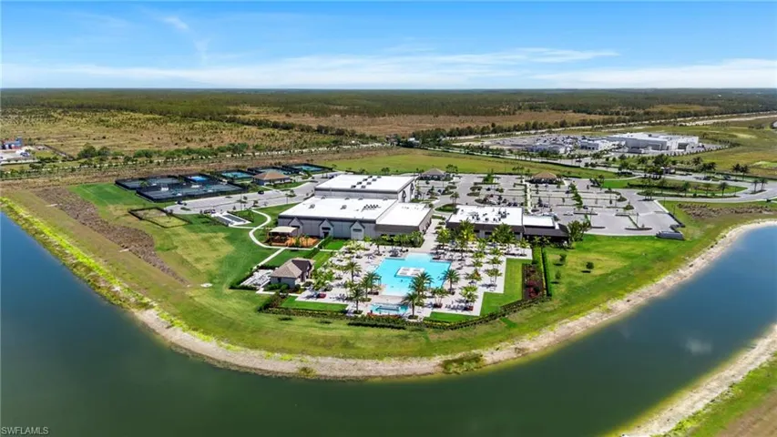 Aerial view of a resort-style pool, amenity center, sports complex, and community restaurant/craft bar.