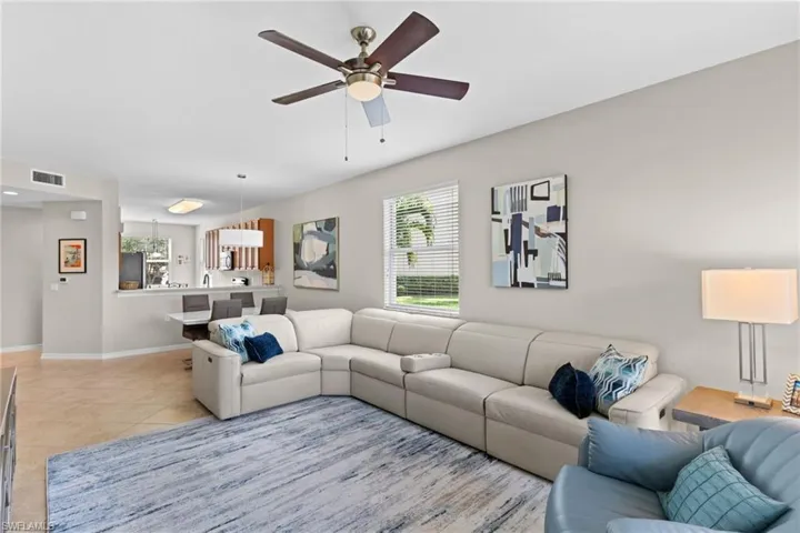 Living area featuring a ceiling fan and light tile patterned floors