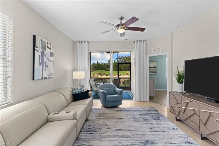 Living room with ceiling fan and light tile patterned floors