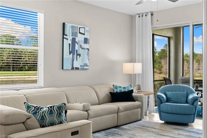 Living room featuring tile patterned floors and a ceiling fan