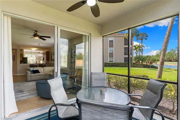 Sunroom / solarium with ceiling fan, outdoor dining area, and a water view