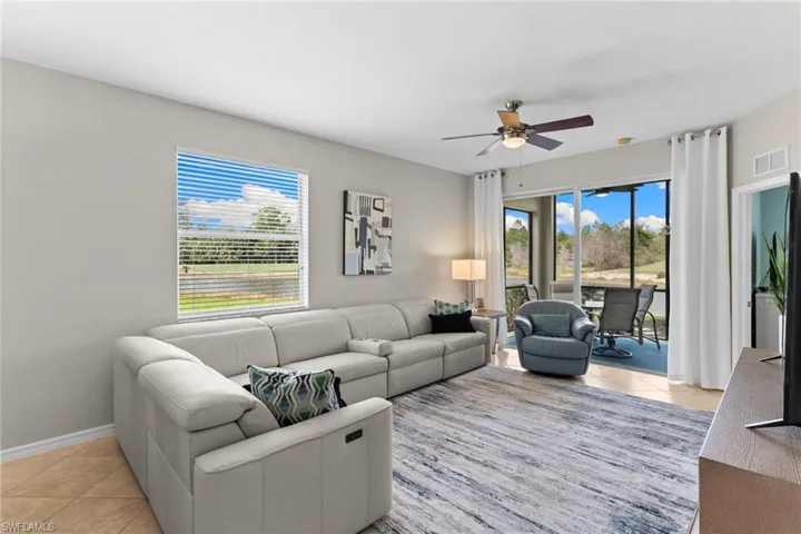 Living area featuring ceiling fan and light tile patterned floors