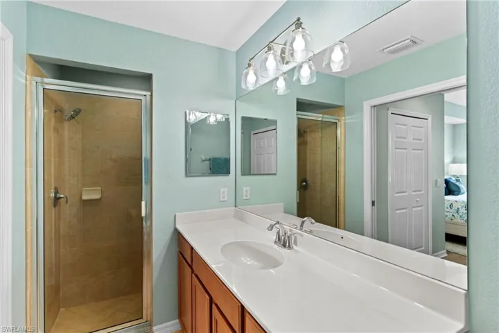 Bathroom with ensuite bath, a stall shower, and vanity