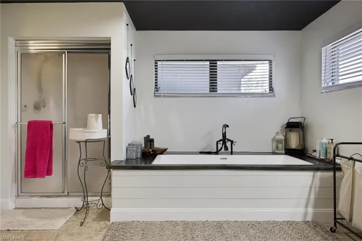 Bathroom with independent shower and bath and tile patterned floors