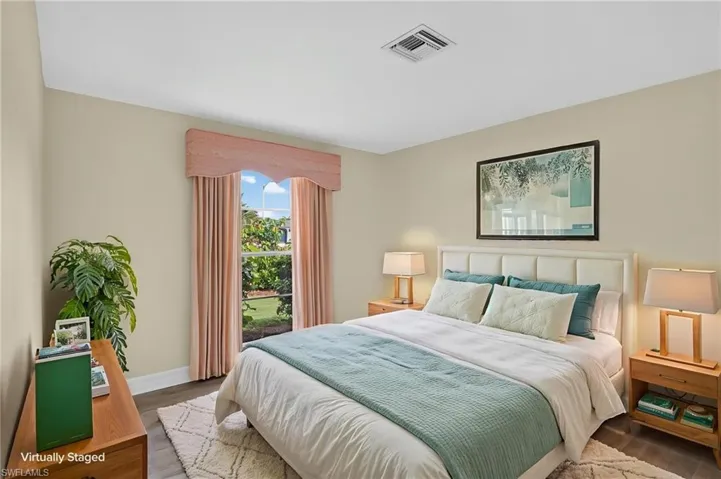 Recessed ceiling air vent, light neutral wall color, and wood-finish flooring