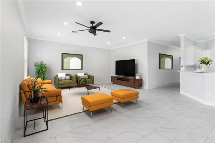 Living room with crown molding and ceiling fan