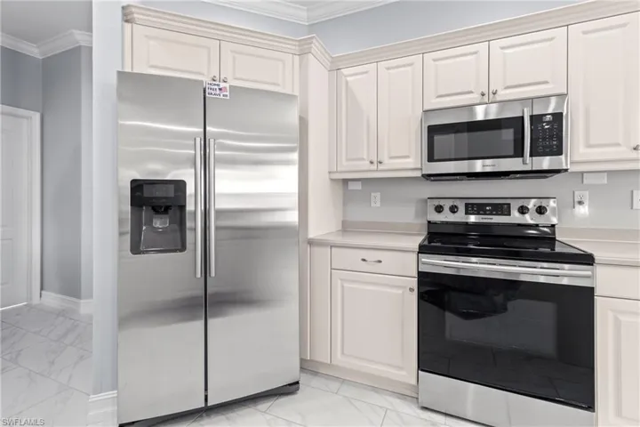 Kitchen featuring ornamental molding and appliances with stainless steel finishes