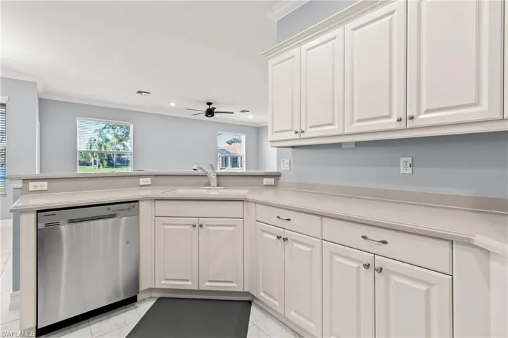Kitchen featuring sink, stainless steel dishwasher, white cabinets, and kitchen peninsula