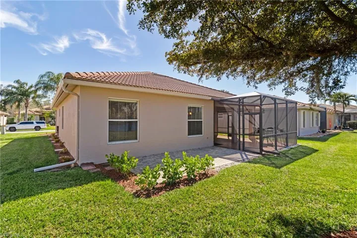 Rear view of house featuring a yard, a lanai, and a patio
