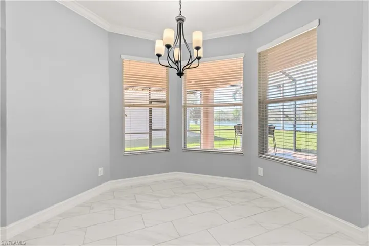 Unfurnished room with a notable chandelier and crown molding