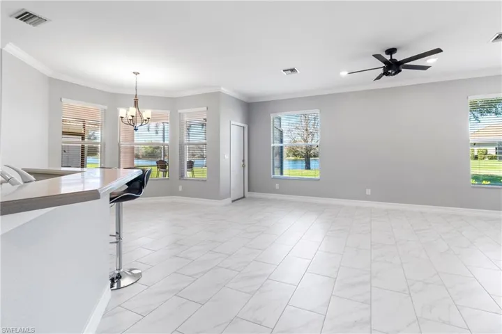 Living room featuring ornamental molding and ceiling fan with notable chandelier