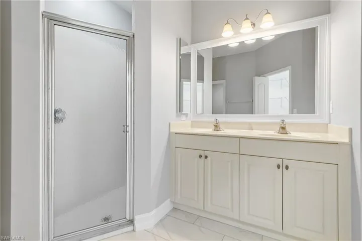 Bathroom featuring a shower with door and vanity