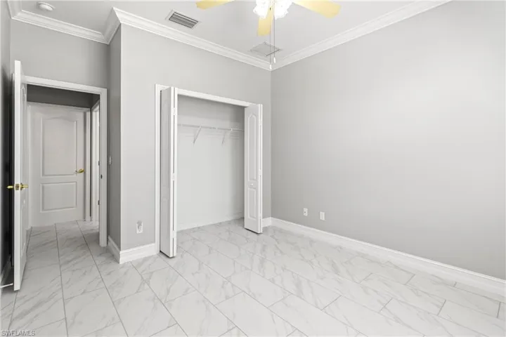 Unfurnished bedroom with crown molding, a closet, and ceiling fan