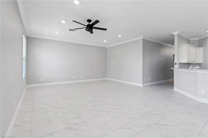 Spare room featuring crown molding and ceiling fan