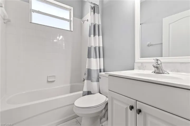 Full bathroom featuring vanity, shower / tub combo, and toilet