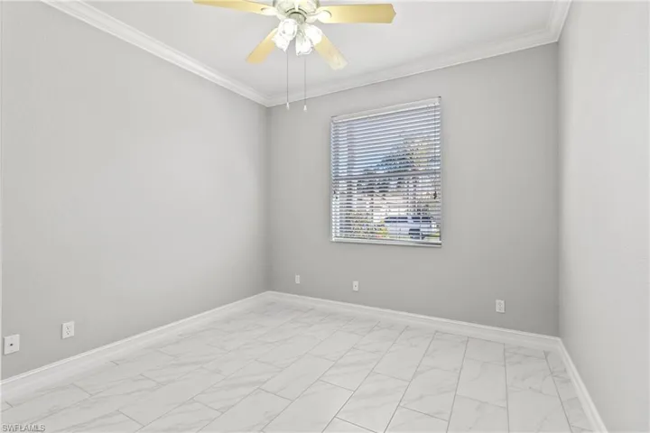 Spare room featuring crown molding and ceiling fan