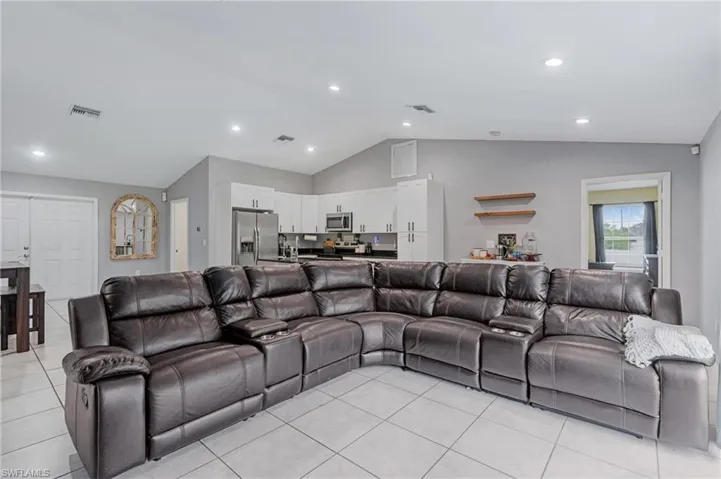 Living room with high vaulted ceiling and light tile floors