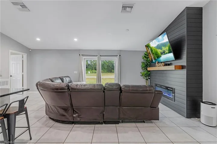 Living room featuring a fireplace and light tile floors