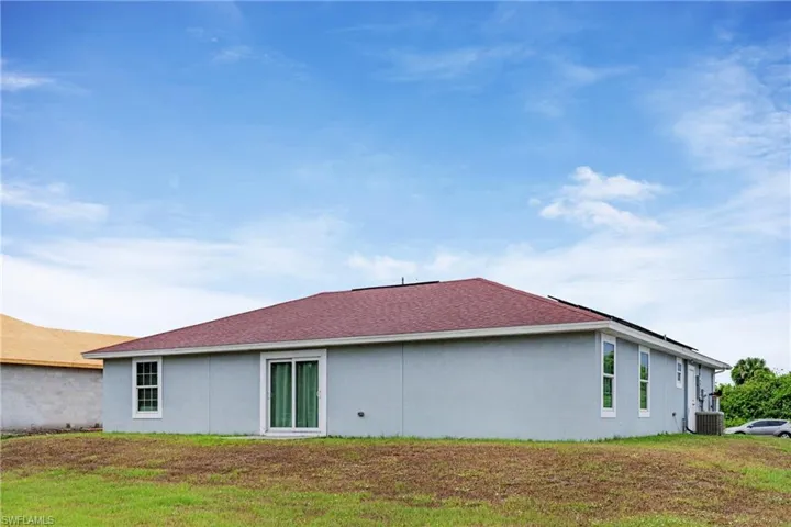 View of home's exterior featuring a lawn and central AC unit