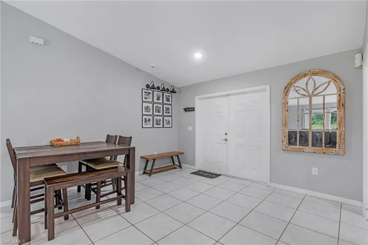 Dining area featuring lofted ceiling and light tile floors