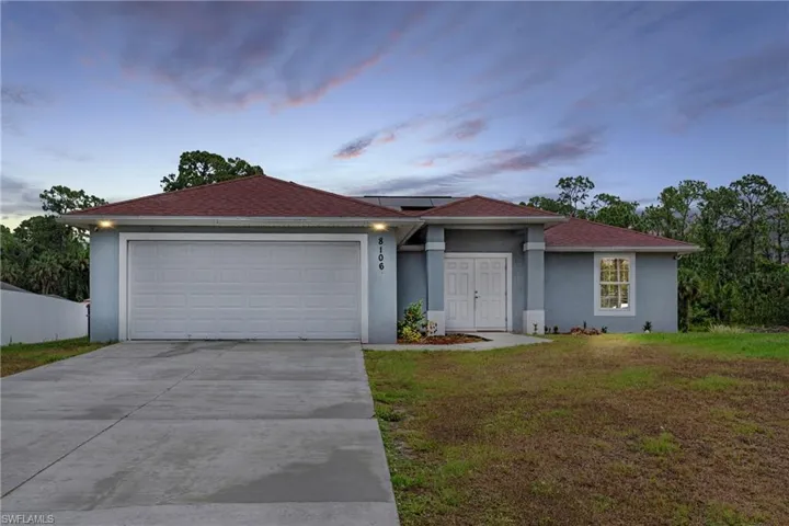 Ranch-style house with a garage and a yard