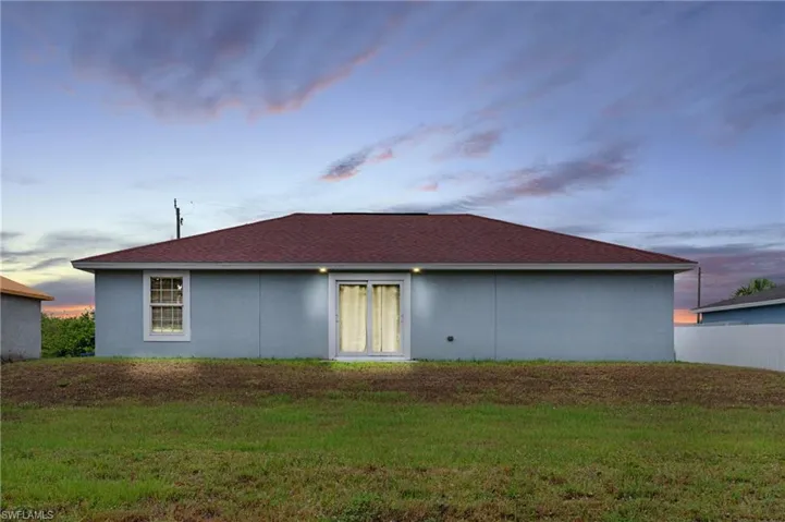 Property exterior at dusk featuring a yard