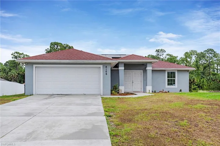 Ranch-style home featuring a garage and a front lawn